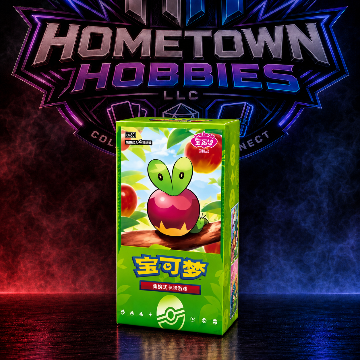 A green box of Pokémon TCG trading cards featuring the Pokémon logo and a red apple with a leaf on the front, displayed in front of a large Hometown Hobbies LLC logo on a smoky, colored background.