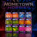 A 16-pack display of Hometown Hobbies LLC Squeaky Cubes, featuring marbled swirls of orange, blue, green, yellow, and pink, set against a dark background with a glowing Hometown Hobbies logo.