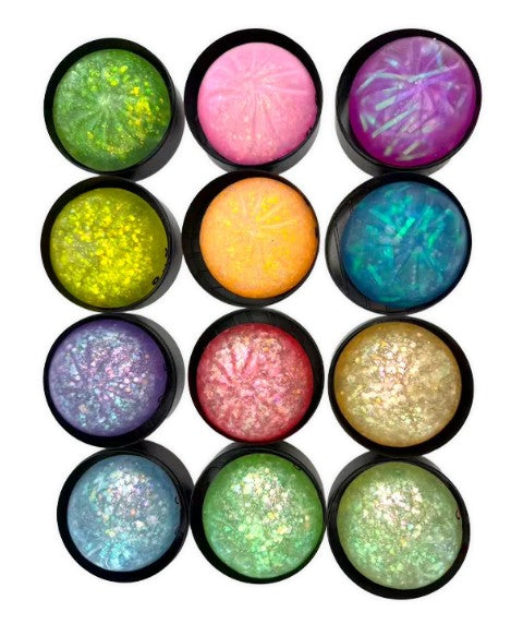 Twelve round cosmetic pans of glittery pressed powder in assorted vibrant colors, arranged in a 4-by-3 grid on a plain white background.