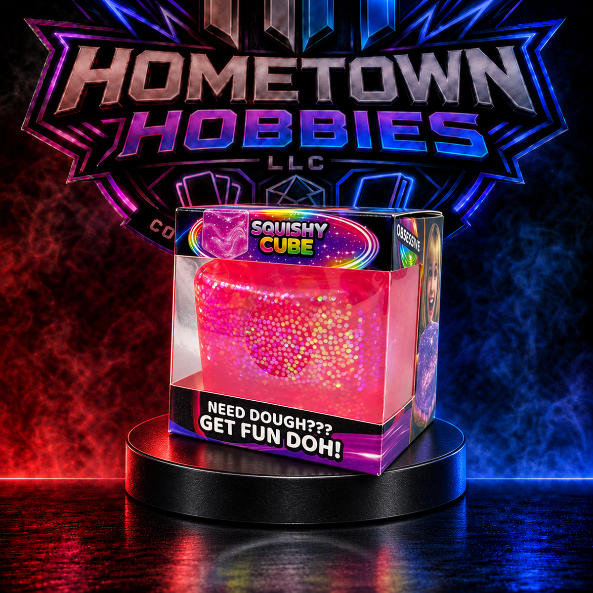 A pink and red glittery squishy cube toy inside a clear plastic box with a purple and black base, displayed on a black pedestal in front of a glowing Hometown Hobbies LLC logo.