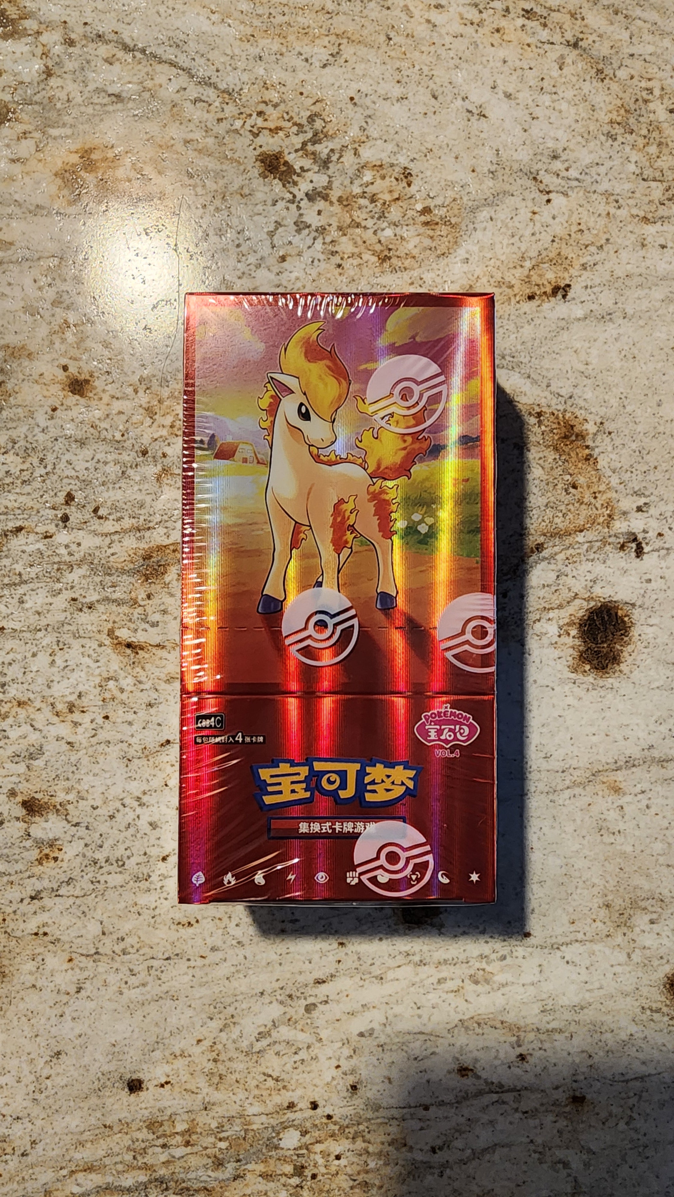 A sealed Pokémon booster pack featuring Vaporeo on the front, photographed flat on a speckled beige stone surface with a cast shadow.